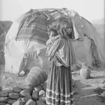 Woman with baby and hut